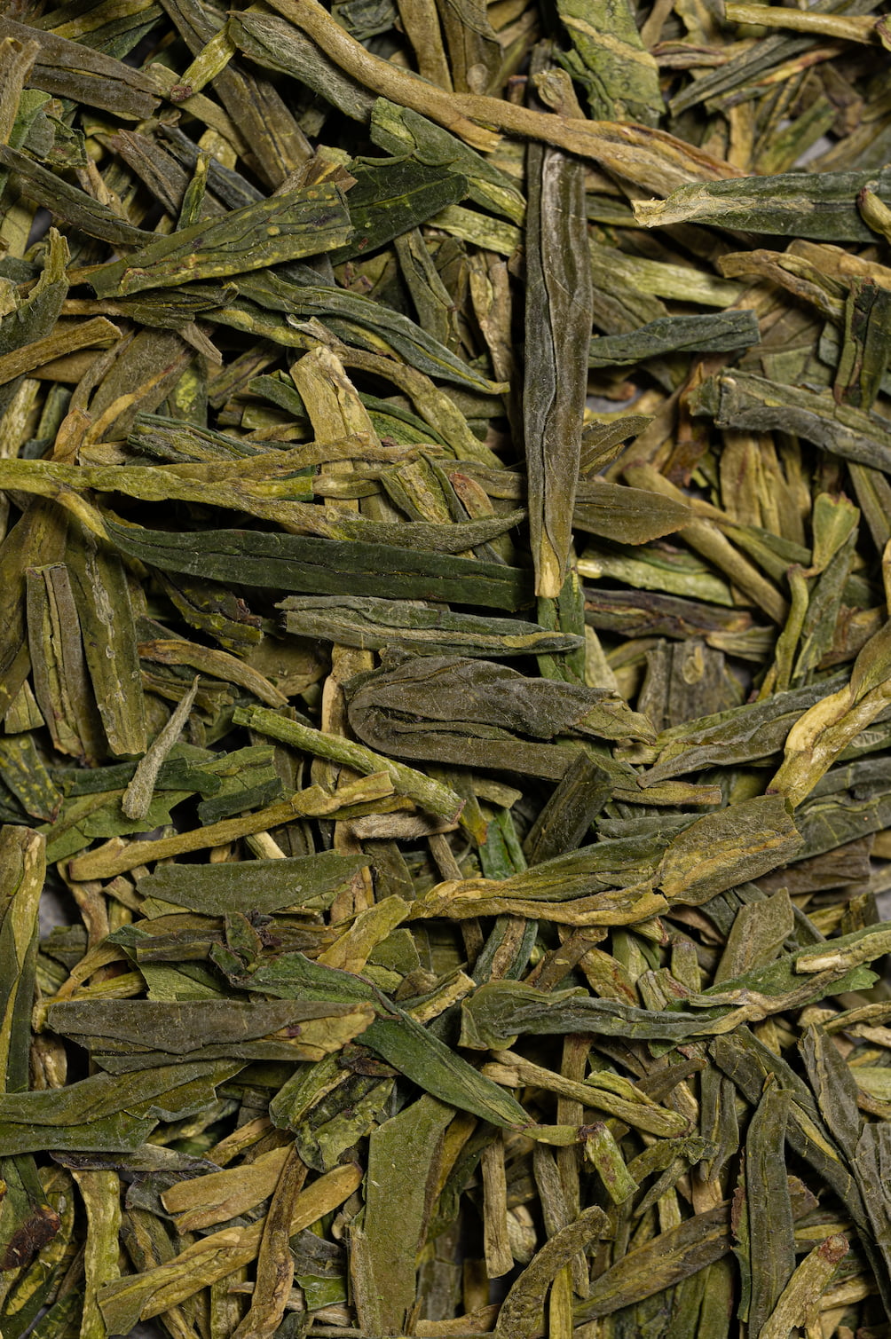 Longjing – Makroaufnahme der Grünteeblätter.