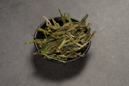 Longjing – Grünteeblätter in einer Schale.