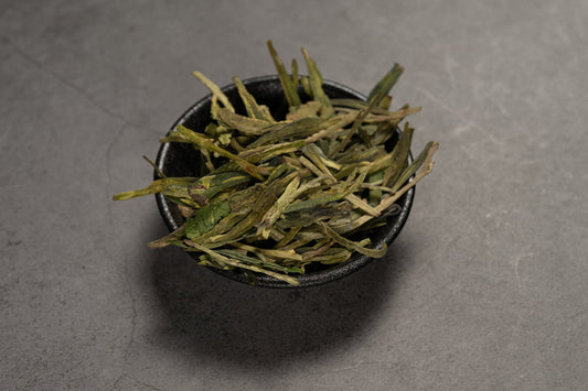 Longjing – Grünteeblätter in einer Schale.